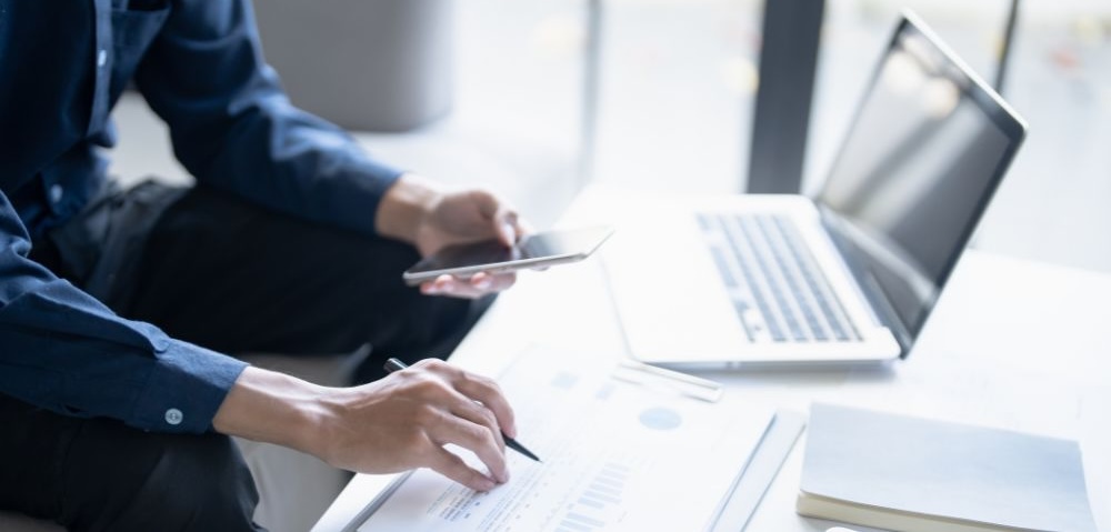 Man calculate finances home pay bills taxes on mobile phone and