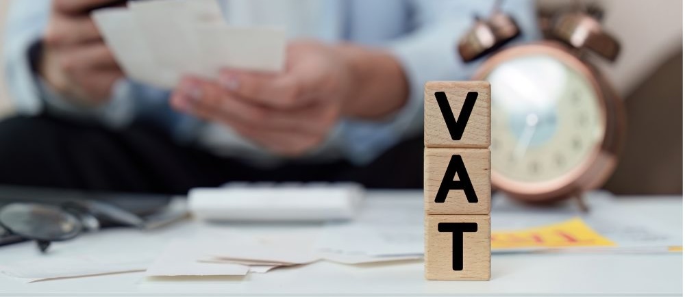 VAT Management. Individual reviewing VAT documents with clock. VAT Management. Individual reviewing VAT documents with clock.